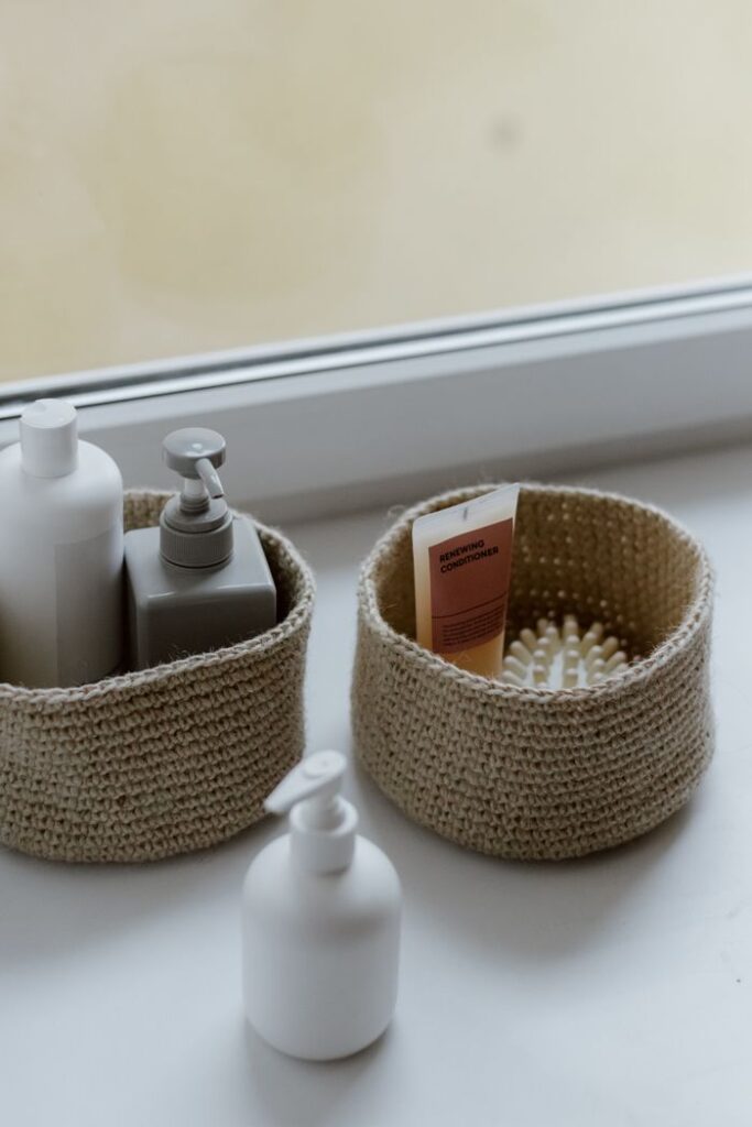 Home Minimalistic display of self-care products in woven baskets on a windowsill, creating a calm home interior vibe.